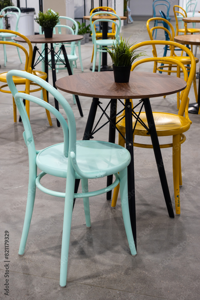 Colorful wooden chairs and tables in a public restaurant. Public places for eating quick meals.