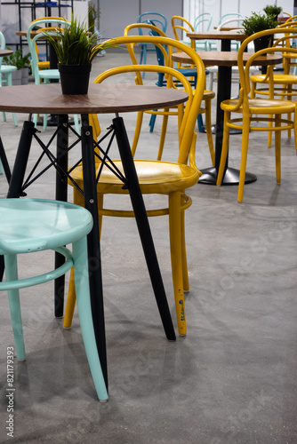 Colorful wooden chairs and tables in a public restaurant. Public places for eating quick meals.