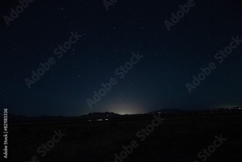 The stars and glow from a distant small town at night