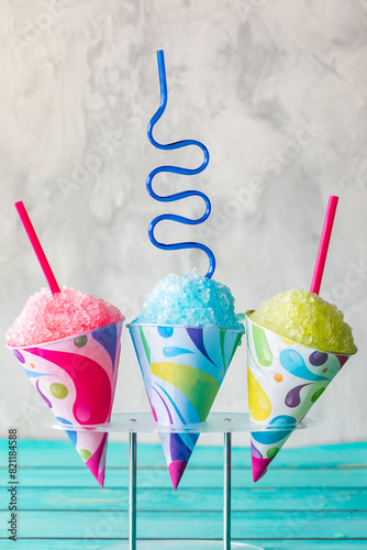 Colourful snow cones in a stand against a light background.