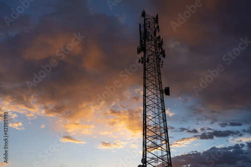 A communications tower with colorful clouds in the background