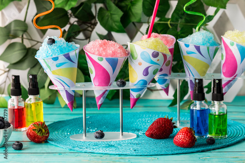 Various colourful snow cones with fruit flavoured syrups.