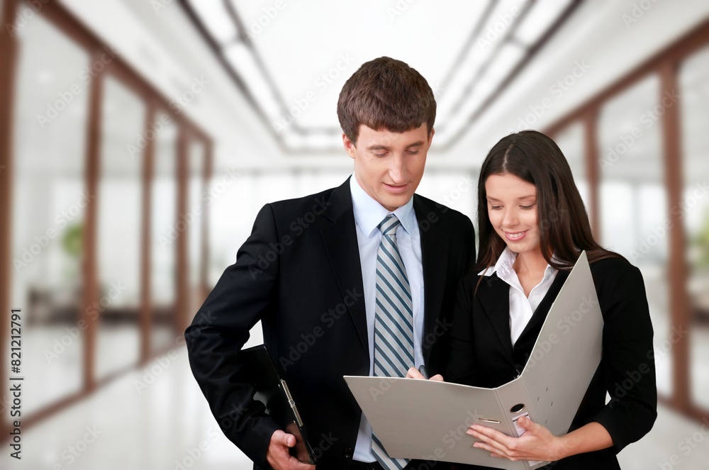 Happy confident business man and woman standing in office Happy confident business man and woman standing in office