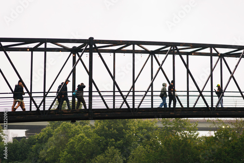 People Crossing an Industrial Metal Bridge © Bryan