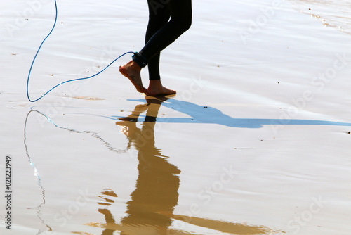 An athlete walks barefoot on the sand on the seashore.