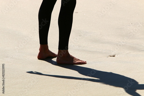 An athlete walks barefoot on the sand on the seashore.