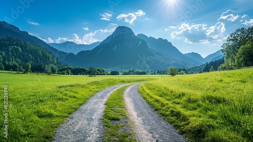 Country road and green meadow with mountain nature landscape under the blue sky