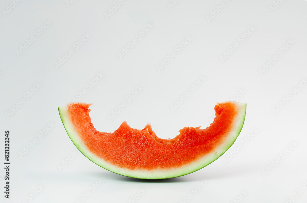 A sweet slice of red watermelon, with bites, seedless, on a smooth background A sweet slice of red watermelon, with bites, seedless, on a smooth background