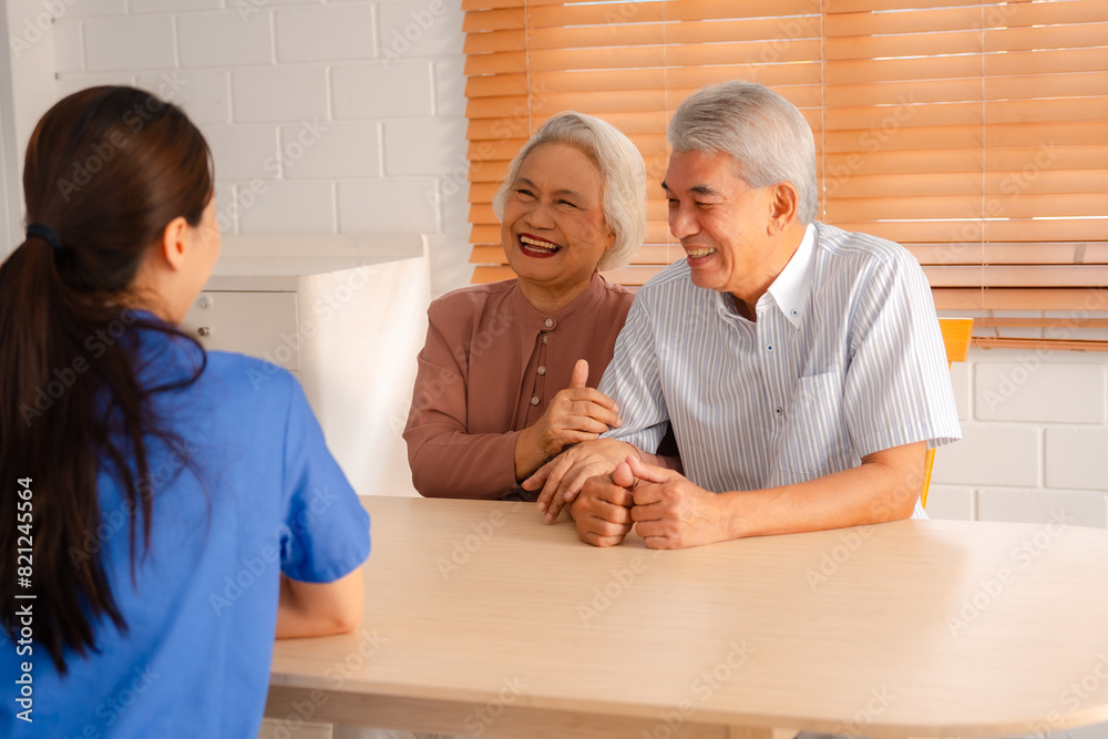 Fototapeta premium Happy Senior Asian Woman Receives Medical Care at Home, Doctor or Caregiver Nurse Provide Support Assistance, Enhancing Healthcare Services for Elderly Patients Retirement