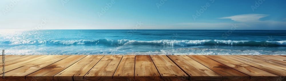 Fototapeta premium Beautiful sunny day at the beach with clear blue skies and gentle waves in the ocean viewed from a wooden deck.