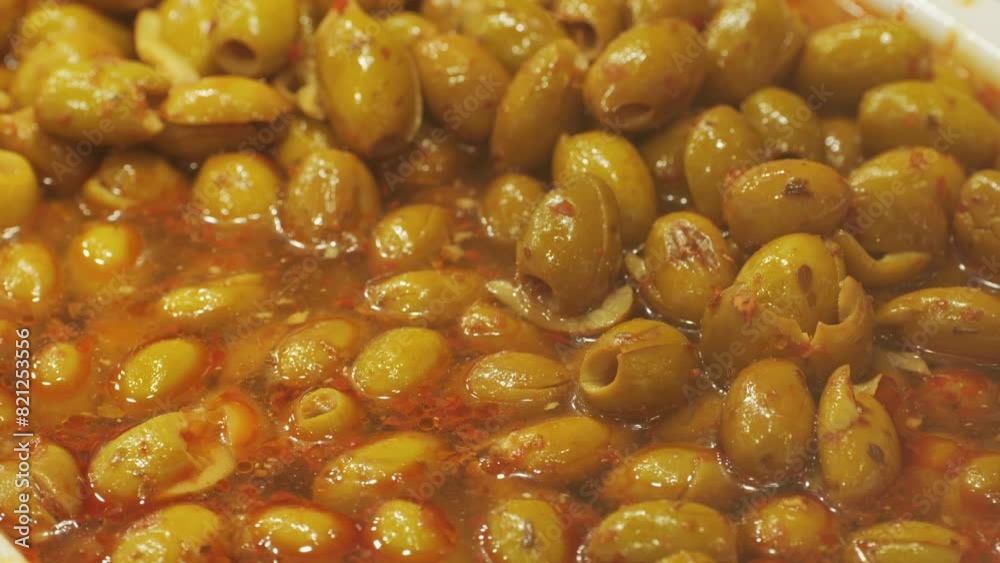 Marinated green olives in spicy sauce, spanish traditional food, ideal for Mediterranean dish or snack, market in barcelona. Marinated green olives in spicy sauce, spanish traditional food, ideal for Mediterranean dish or snack, market in barcelona.