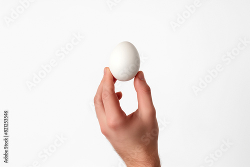 Conceptual photo of a hand holding an egg, isolated on a white background,