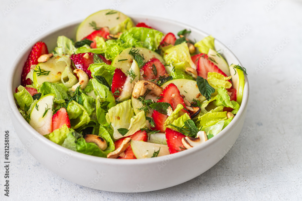 Fresh salad with lettuce leaves, apples, strawberries and cashew nuts Fresh salad with lettuce leaves, apples, strawberries and cashew nuts