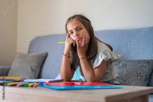 9-year-Old Girl With A Tired Expression Studying.Homeschooling. Summer school. Real elementary student. Back to school.