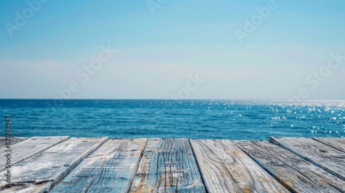 Scenic view of a wooden pier extending into a tranquil blue ocean under a clear sky, perfect for a serene coastal getaway. Copy space included. © Rattanathip