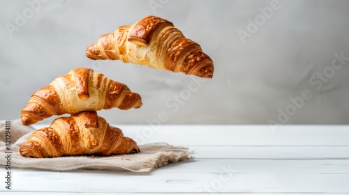 Croissants that fresh and delicious falling in the air isolated on background, breakfast time, popular plain croissant breads., generated with ai