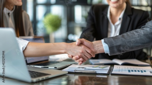 Two People Shaking Hands in Front of Laptops
