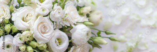 A panoramic close-up of a white rose and ranunculus bouquet on a light background