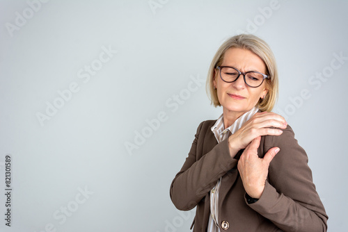 Принти на полотні Mature business woman with pain grimace on her face has shoulder pain in front o