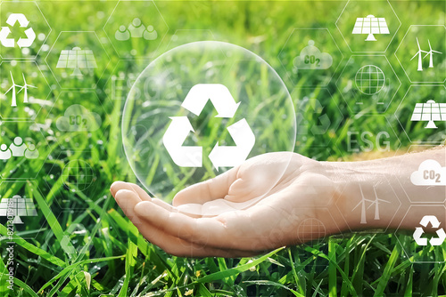 Hand holding Recycling concept - recycling symbol with green grass background. Save clean planet, Save world and environment, Ecology, World Earth Day Concept