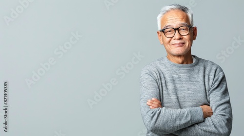 An older man in glasses and a sweater gazes thoughtfully
