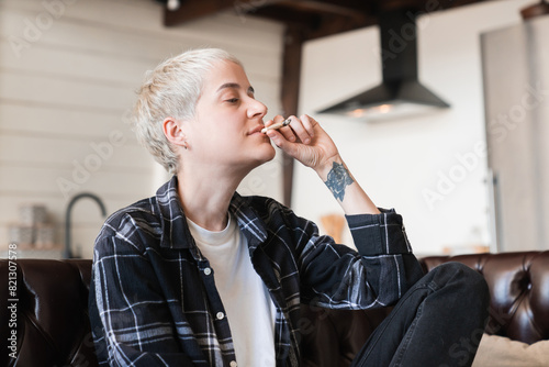 Hipster woman girl smoking cigarette joint with marijuana cannabis tobacco hashish. Legalization of drugs for pain relief. Smoke addiction.