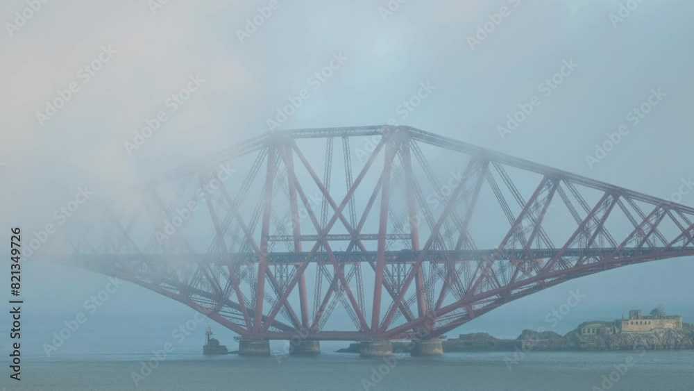 A train travelling over a railway bridge covered in thick fog. Forth Bridge, Scotland, United Kingdom A train travelling over a railway bridge covered in thick fog. Forth Bridge, Scotland, United Kingdom