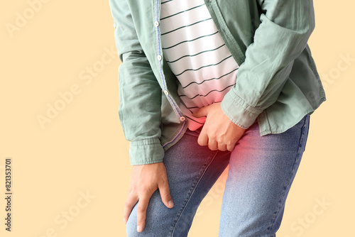 Man with prostate problem on beige background, closeup photo