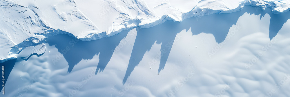 Fototapeta premium Aerial View of Snow-Covered Mountain Range with Shadows