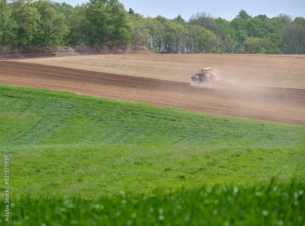 Obraz premium 土煙を上げるトラクター / Tractor making a cloud of dust