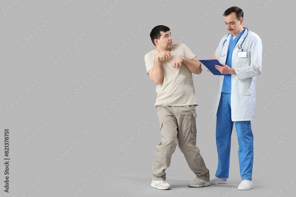 Young man with doctor on light background. National Cerebral Palsy Awareness Month Young man with doctor on light background. National Cerebral Palsy Awareness Month
