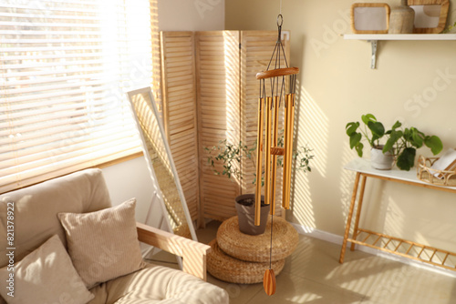 Fotografie Golden wind chime hanging in light living room, closeup