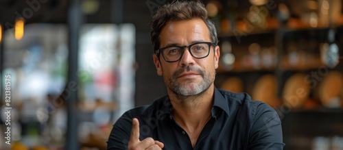 Confident man with glasses giving thumbs up photo