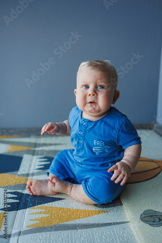 Little baby boy with a toy crawling on the floor at home