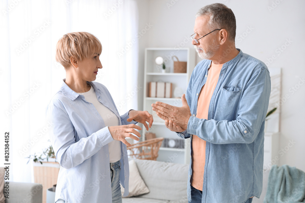 Fototapeta premium Mature deaf mute couple quarrelling in sign language at home