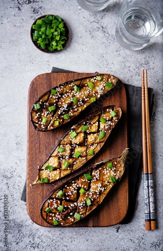 Teriyaki sesame seed baked eggplant in a cut board photo