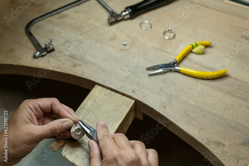 Female jeweler fixing a metal bail on silver pendant