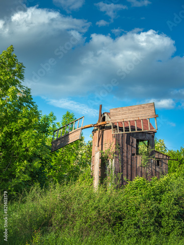 portrait view to old abandoned windmill under blue sky with clouds in Ukraine