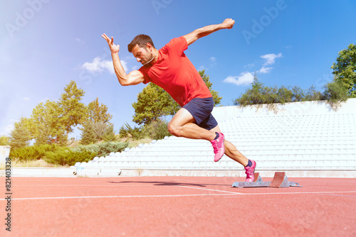 Stadium, man running and start block of athlete on a runner and arena track for sprint