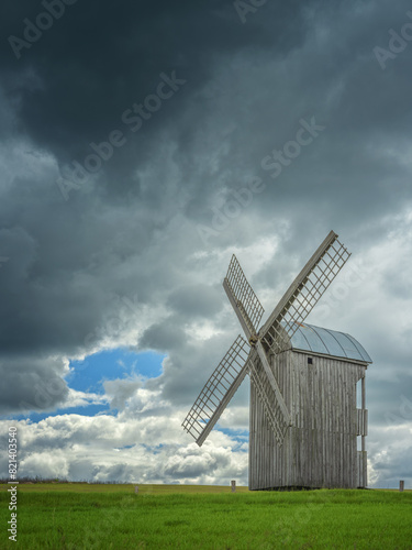old wooden Urainian windmill under dramatic clouds