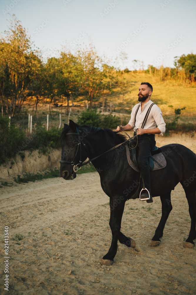 Full length of equestrian in western outfit horseback riding at ranch. Full length of equestrian in western outfit horseback riding at ranch.