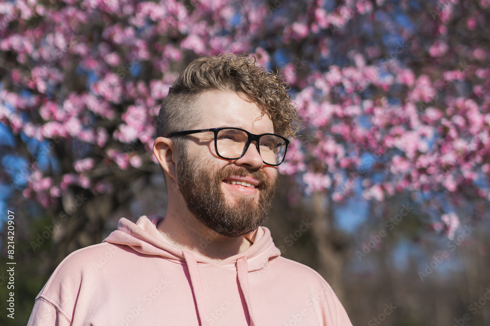 Man allergic enjoying after treatment from seasonal allergy at spring. Portrait of happy bearded man smiling in front of blossom tree at springtime. Spring blooming and allergy concept. Copy space Man allergic enjoying after treatment from seasonal allergy at spring. Portrait of happy bearded man smiling in front of blossom tree at springtime. Spring blooming and allergy concept. Copy space