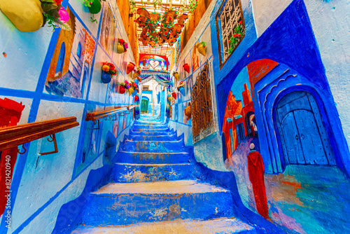 Chefchaouen, Morocco: Blue narow stairs with colourful walls and flowerpots into old walled city, or medina, North Africa © davidionut