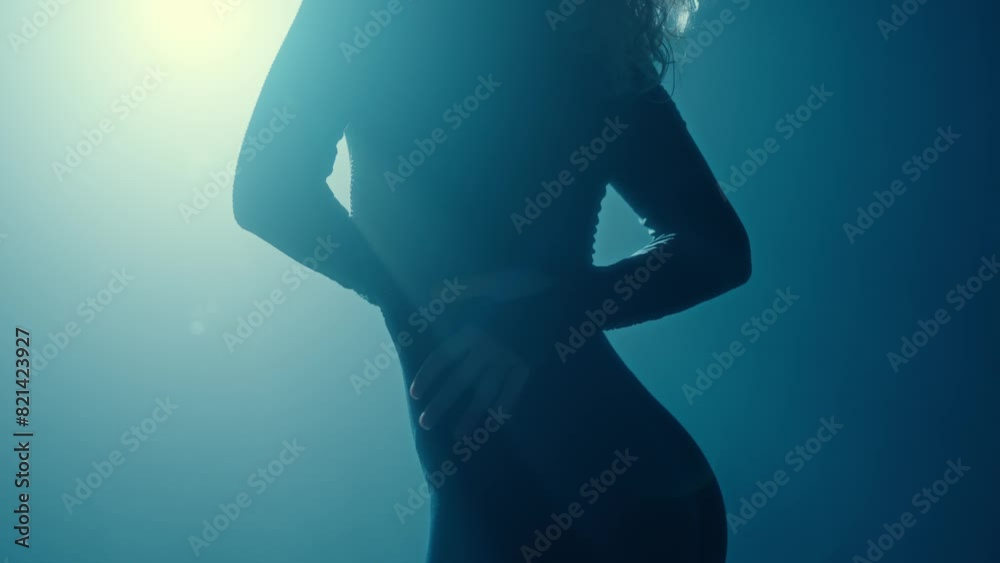 Elegant closeup of a dancer's waistline, highlighted by backlight, capturing movement and grace. Ideal for artistic themes.