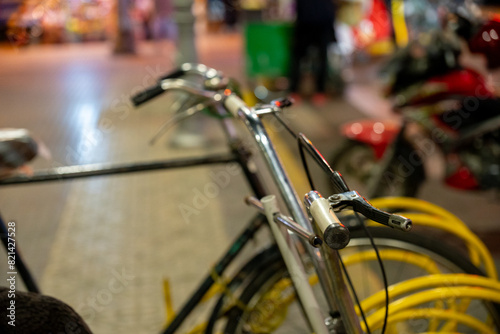 Close up of bicycle handlebars, bicycles parked in a public place, urban transportation