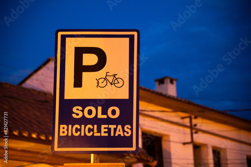 sign for a bicycle parking lot, isolated from the background at night