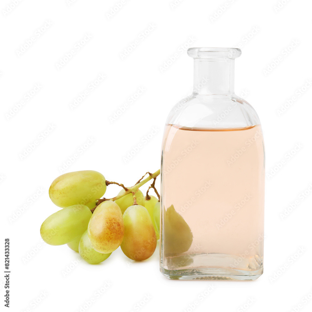 Grape vinegar in bottle and berries isolated on white Grape vinegar in bottle and berries isolated on white
