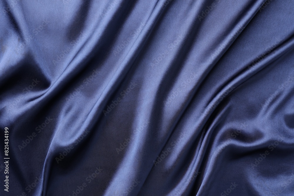 Fototapeta premium Crumpled dark blue silk fabric as background, top view