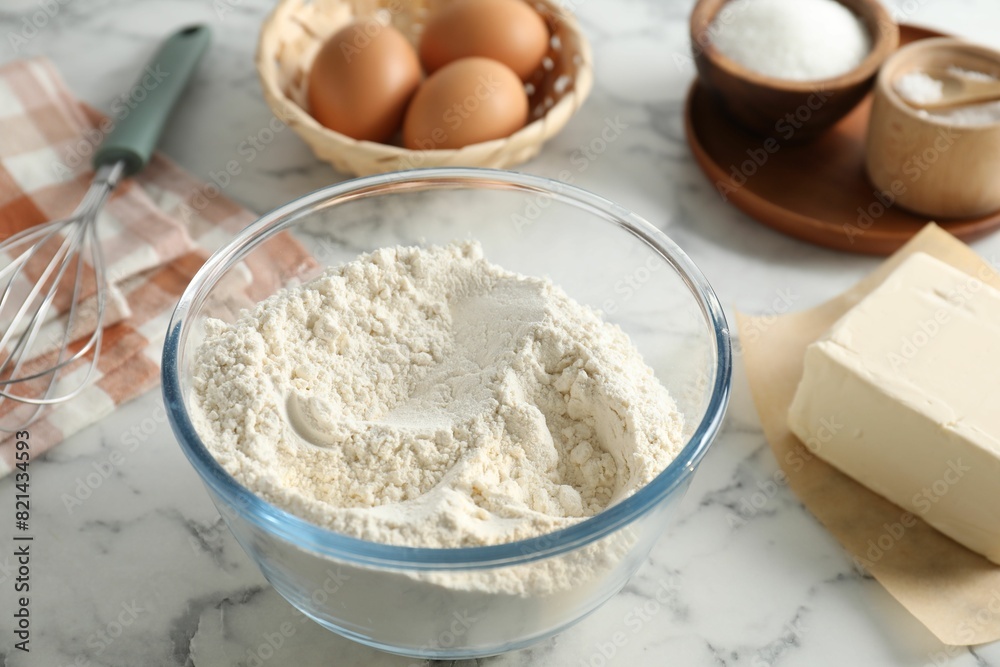 Making shortcrust pastry. Different ingredients for dough and whisk on white marble table Making shortcrust pastry. Different ingredients for dough and whisk on white marble table