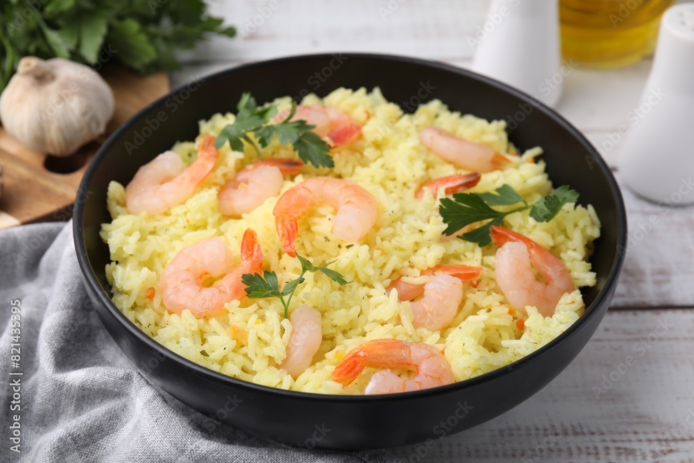 Delicious risotto with shrimps and parsley in bowl on white wooden table, closeup Delicious risotto with shrimps and parsley in bowl on white wooden table, closeup